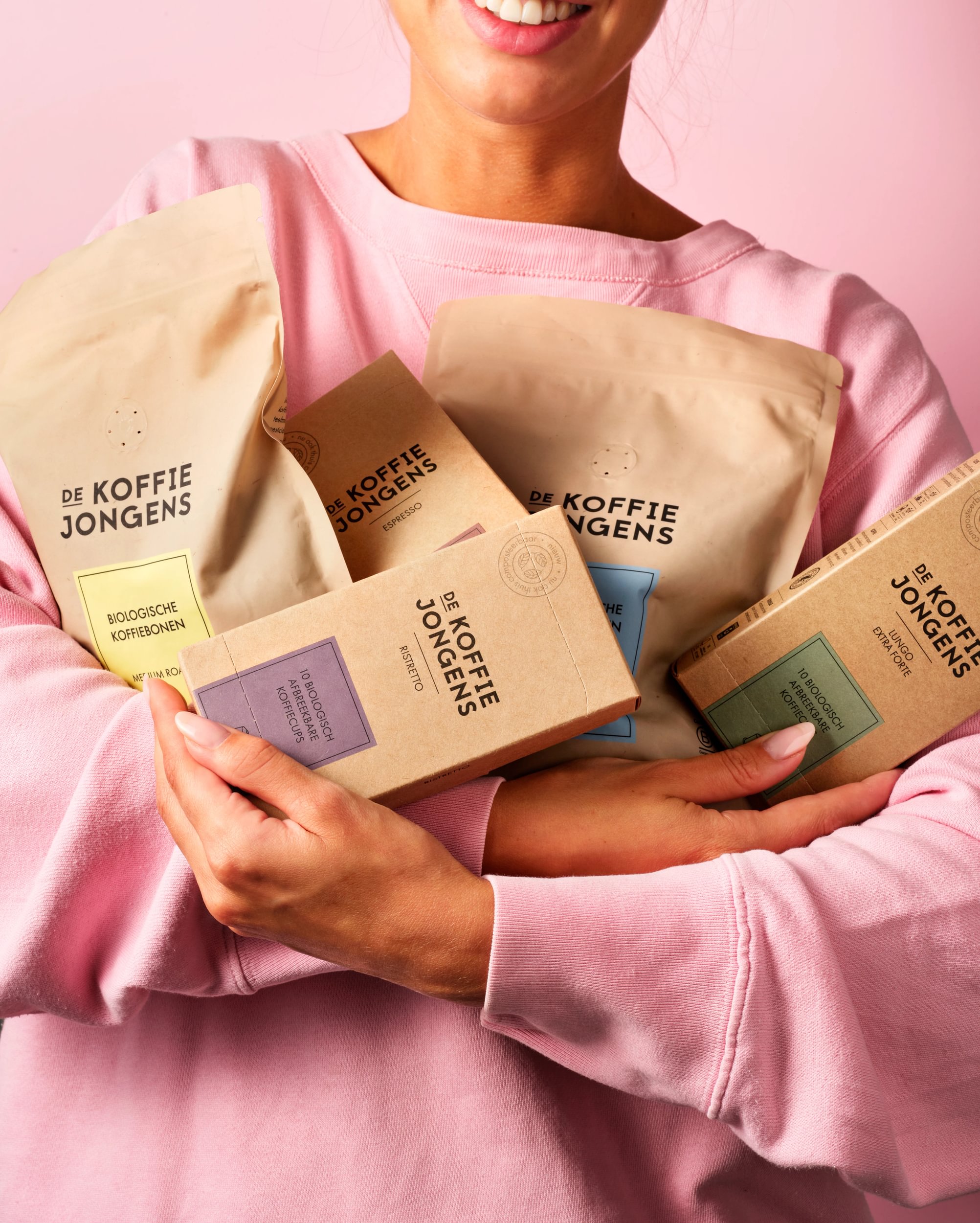 De Koffiejongens - koffiecups en koffiebonen in de hand